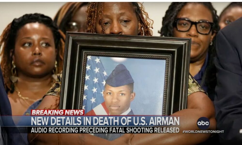 family holding framed picture of their son in an air force uniform