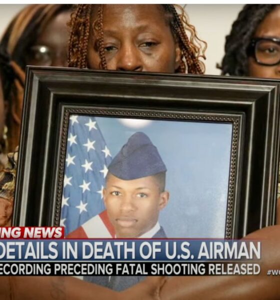 family holding framed picture of their son in an air force uniform